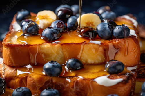 Pouring maple syrup on a pancake with blueberries and bananas photo