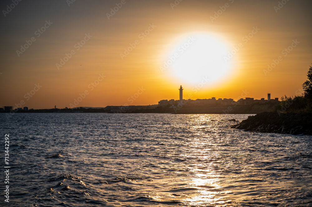 Sunset at the sea, the beach, and the lighthouse