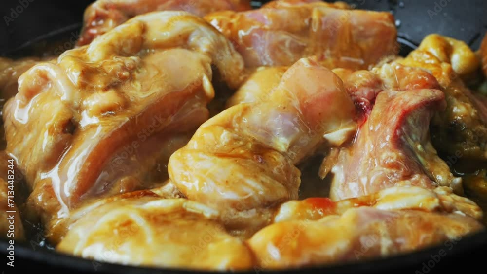 Chicken pieces marinated in teriyaki sauce are fried in a frying pan. Close-up Chicken pieces marinated in teriyaki sauce are fried in a frying pan. Close-up