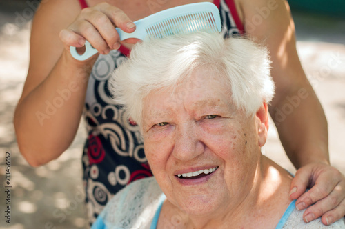 elderly senior woman having her hair combed