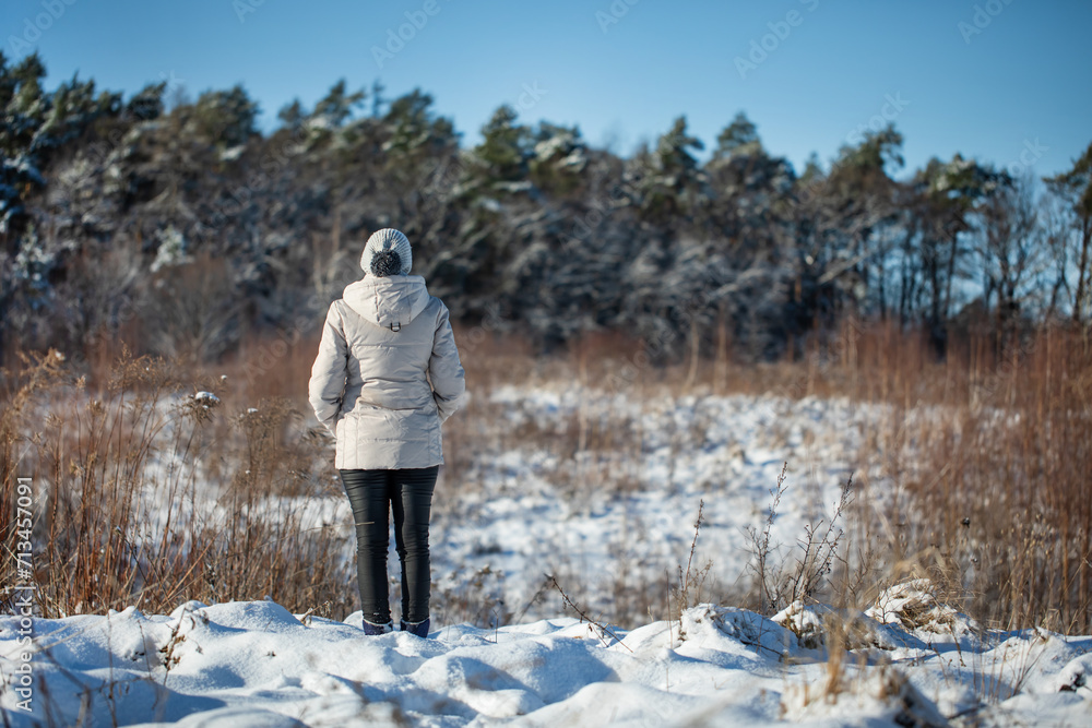 Młoda kobieta spacerująca zimą po górskim szlaku śnieżnym - obrazy, fototapety, plakaty 