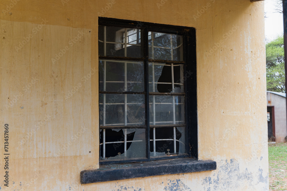 broken window with burglar bars on an old building, colonial architecture vintage in a village in Botswana, design elements and textures