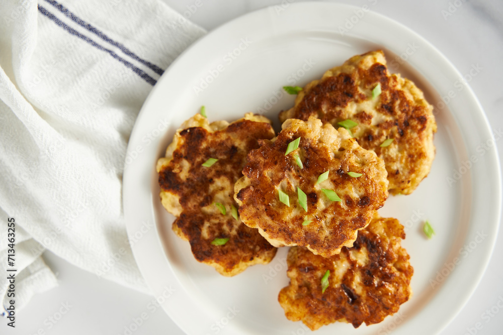 Golden Brown Chopped Chicken Cutlets or Patties with mozzarella cheese on white plate.. Minimalistic food photo on white marble background. Top view Golden Brown Chopped Chicken Cutlets or Patties with mozzarella cheese on white plate.. Minimalistic food photo on white marble background. Top view