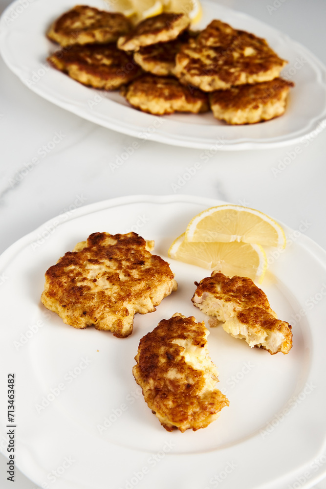 Golden Brown Chopped Chicken Cutlets or Patties with mozzarella cheese on white plate.. Minimalistic food photo on white marble background Golden Brown Chopped Chicken Cutlets or Patties with mozzarella cheese on white plate.. Minimalistic food photo on white marble background