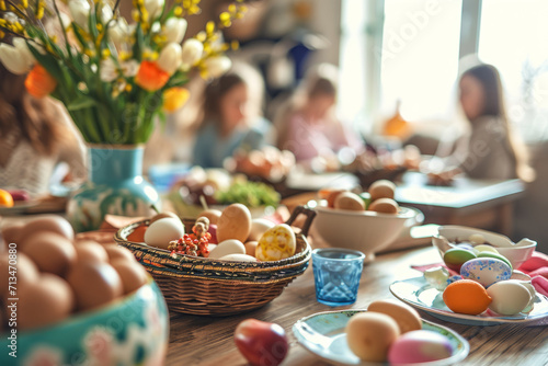 Family having festive dinner together. Table setting with traditional food and spring flowers for Easter celebration