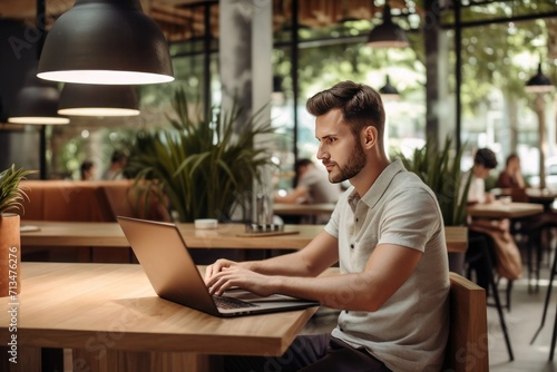 Young man freelancer with working on table by laptop in cafe or coworking space, work from home and remote job concept with laptop