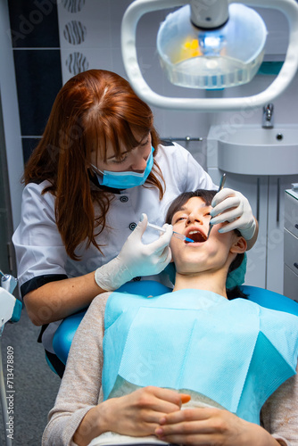 Woman Receives Dental Check-up and Treatment by Dentist. A woman receives a thorough dental check-up and treatment from a highly skilled dentist.