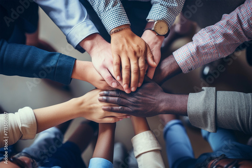 A group of different people put their hands on top of each other, the concept of bringing different people together, the concept of multiracial cooperation and neighborly worldviews photo