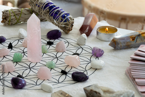 A close up image of a crystal healing grid with sage smudge sticks and crystal towers.  photo