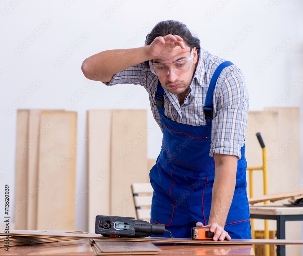 Young male carpenter working indoors Young male carpenter working indoors