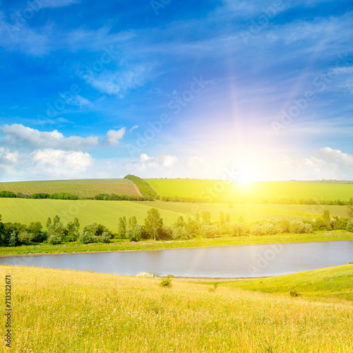 Agricultural fields, meadows, lake and bright sun.