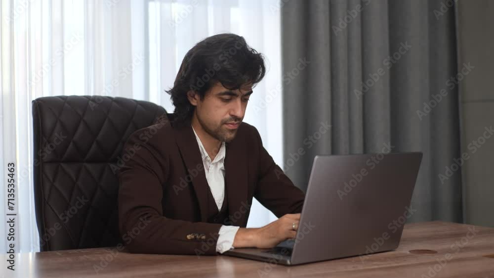 Tired overwhelmed young businessman in suit working on computer, suffering from eyes fatigue or having painful feelings. Exhausted executive manager overworked in office. Shooting in slow motion. Tired overwhelmed young businessman in suit working on computer, suffering from eyes fatigue or having painful feelings. Exhausted executive manager overworked in office. Shooting in slow motion.