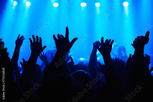 Club, concert and audience with hands or lights for music, party and rave festival with spotlight and dancing. Disco, psychedelic event and performance with entertainment, crowd and rear view gesture
