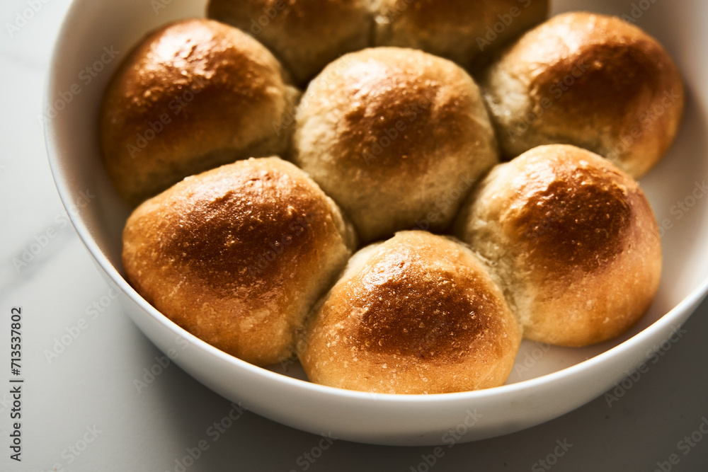 Burger Buns or mini buns in the round baking pan. Very soft Freshly Baked Homemade, buttered. White marble background. Minimalistic photo Burger Buns or mini buns in the round baking pan. Very soft Freshly Baked Homemade, buttered. White marble background. Minimalistic photo