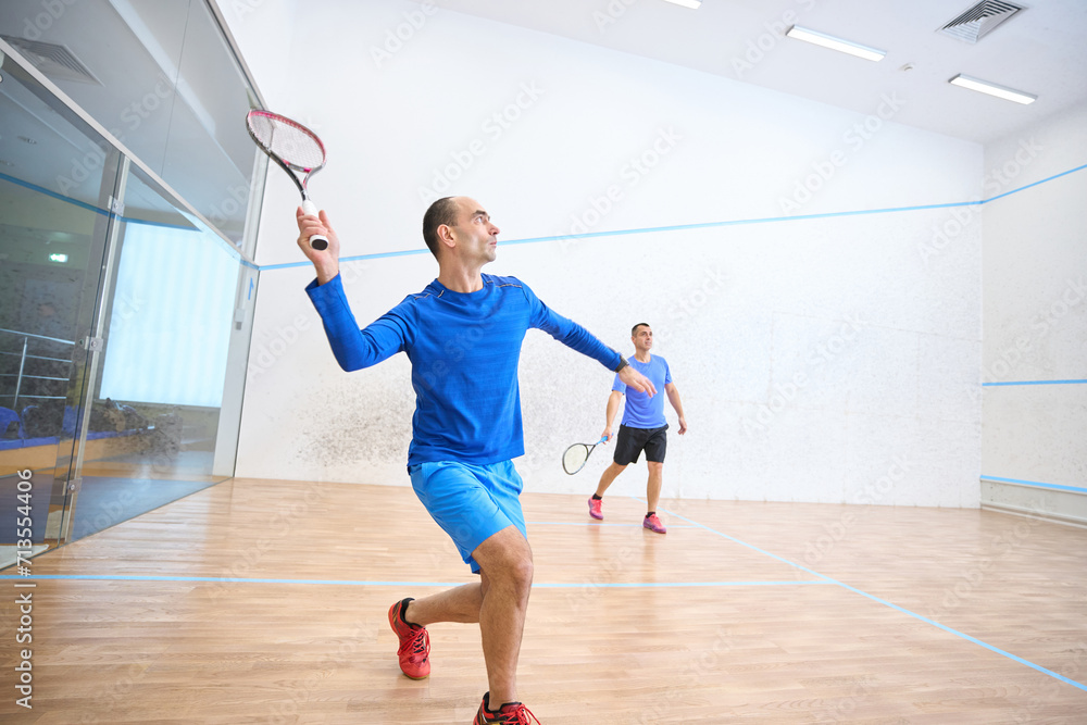 Energetic men training squash enjoying active lifestyle Energetic men training squash enjoying active lifestyle