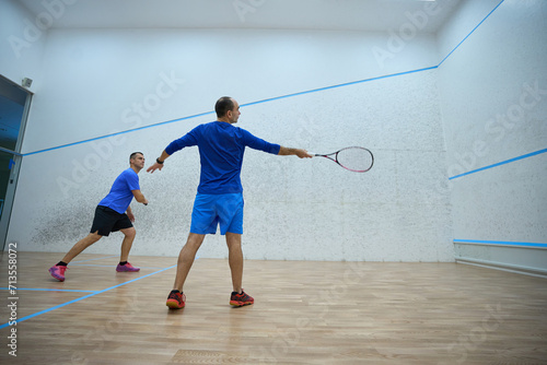 Determined young men are practicing squash together
