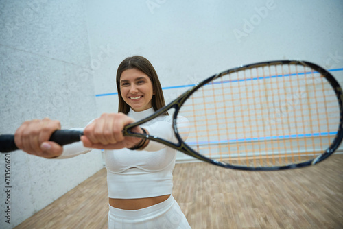 Beautiful smiling athletic woman with squash racket © Viacheslav Yakobchuk