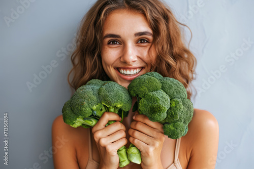 Happy Woman with Broccoli on a Light Gray Background