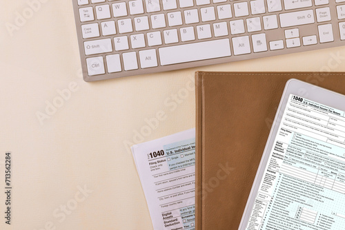 During tax season, accounting office prepares individual income tax form 1040 files it electronically on digital tablet photo