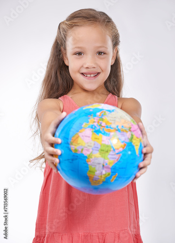 Kid, portrait and globe in studio with world, planets and city for education, geography and happy. Student, girl child and travel map with smile for earth day support or lesson on white background