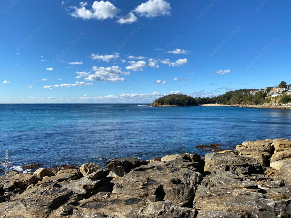 Beach with sky. Rocky coast of the sea. Ocean, mountains, shore and rocks. Bay landscape.