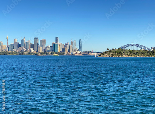 View of Sydney and its iconic buildings, skyscrapers and bridge at the distance. Australian city on the horizon. City skyline from the ocean shore.  © Stephanie
