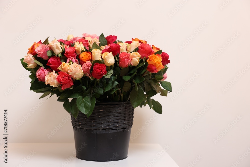 Bouquet of beautiful roses on table against light background. Space for text Bouquet of beautiful roses on table against light background. Space for text