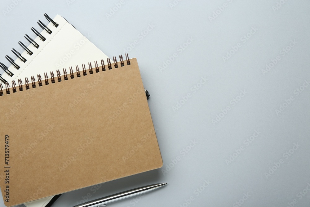 Notebooks on light grey background, top view. Space for text Notebooks on light grey background, top view. Space for text