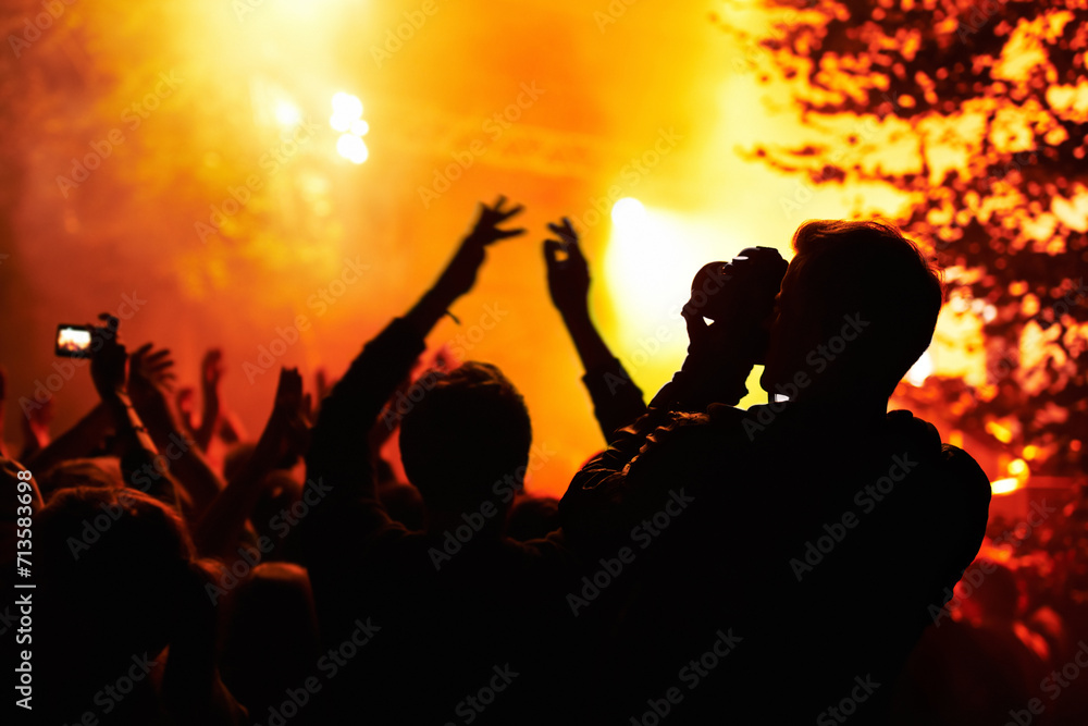 People, silhouette and camera with crowd at festival, music or concert for pictures, social media or news article. Dark, photographer or person with bright, orange and lighting for rock performance People, silhouette and camera with crowd at festival, music or concert for pictures, social media or news article. Dark, photographer or person with bright, orange and lighting for rock performance