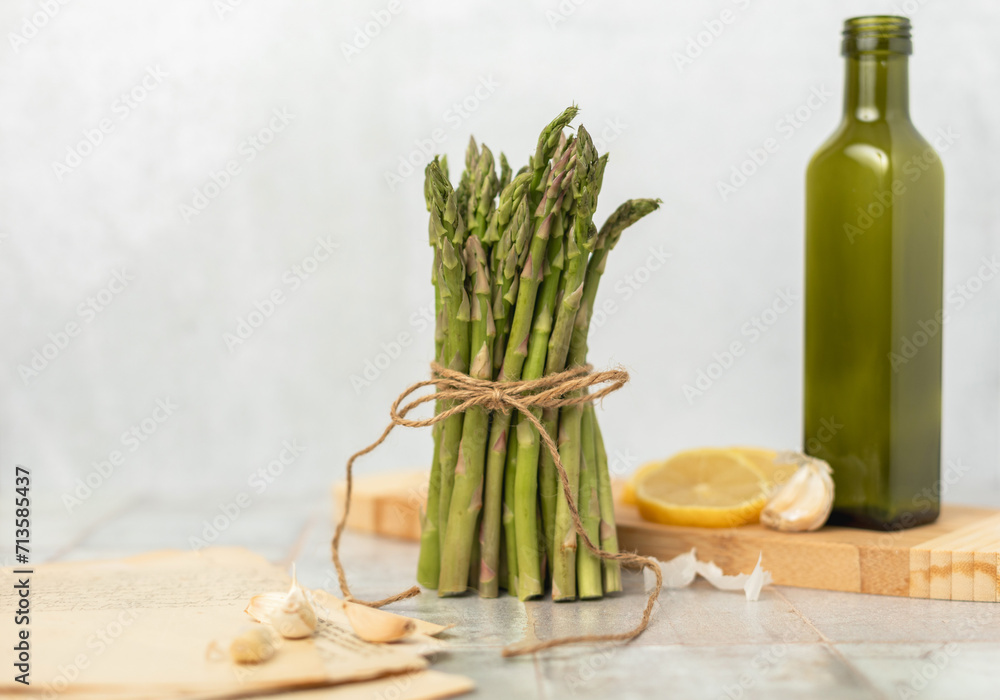 Bunch of Raw Asparagus with Garlic, Lemon, and Olive Oil with Stack of Recipes Bunch of Raw Asparagus with Garlic, Lemon, and Olive Oil with Stack of Recipes