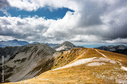 The pass between Vihren and Hvoinati peaks in autumn against Muratov peak. Autumn sunny day in Pirin highlands near Bansko, Bulgaria. photo