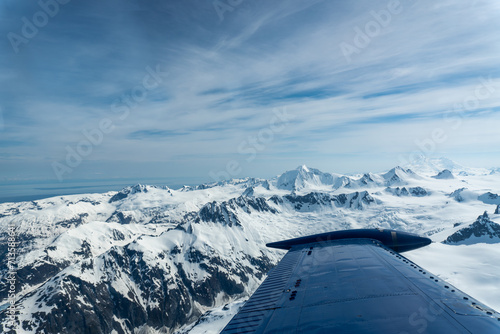 Beechcraft Bonanza airplane wingtip flies over Lake Clark Pass in Alaska. Mount Redoubt in the background. Small aircraft are only way to see many areas of Alaska. photo