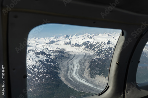 Glacier seen from small airplane in Lake Clark Pass, Alaska. Dark debris lines called lateral or medial moraines along the edges and down the center of glacier. 
