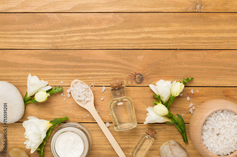 Flat lay with spa products and flowers on wooden background Flat lay with spa products and flowers on wooden background