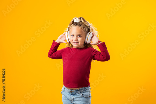 Joyful Child Girl with Headphones, Lost in Music, Expressively Dancing ? Enchanting Image Captured in a Moment of Pure Delight.