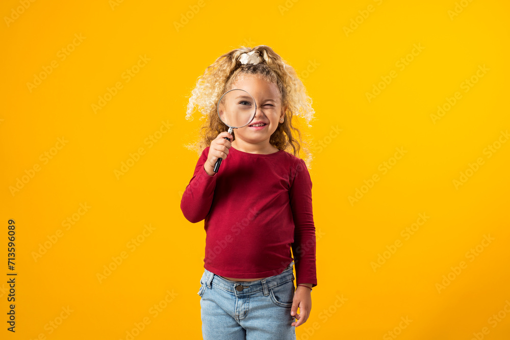 Litle girl holding a magnifier in hand, exploring the world with curiosity, wonder, and a keen sense of discovery. Education and curiosity concept Litle girl holding a magnifier in hand, exploring the world with curiosity, wonder, and a keen sense of discovery. Education and curiosity concept