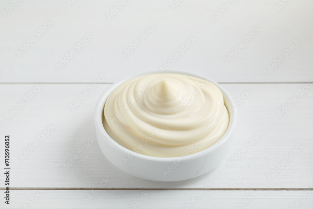 Fresh mayonnaise sauce in bowl on white wooden table Fresh mayonnaise sauce in bowl on white wooden table