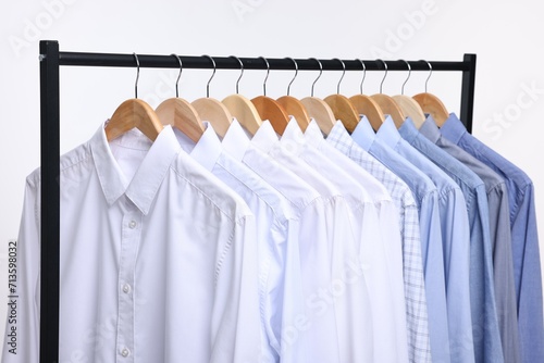 Dry-cleaning service. Many different clothes hanging on rack against white background, closeup © New Africa