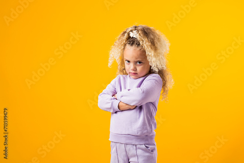 Offended child girl with crossing arms on her chest. Negative human emotions, reactions and feelings. photo