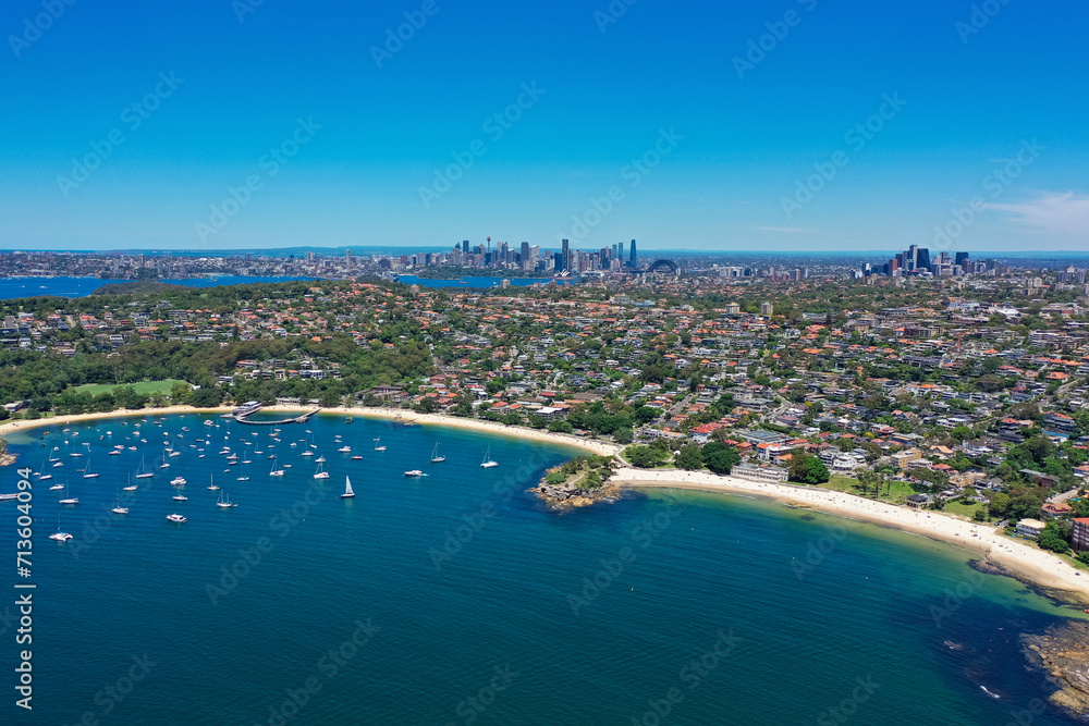 High angle aerial drone view of Balmoral Beach and Edwards Beach in the suburb of Mosman, Sydney, New South Wales, Australia. CBD, North Sydney in the background.