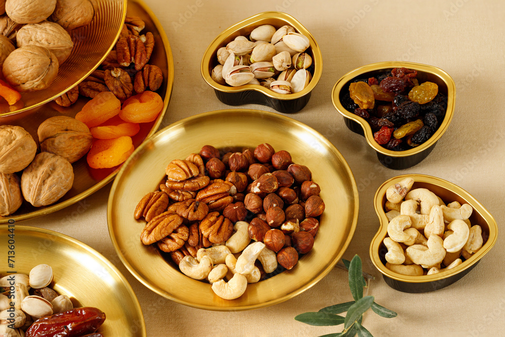 Mixed nuts and dried fruits on a gold plates. Symbols of the Jewish holiday of Tu Bishvat. Healthy snack - mix of organic nuts and dry fruits. Mixed nuts and dried fruits on a gold plates. Symbols of the Jewish holiday of Tu Bishvat. Healthy snack - mix of organic nuts and dry fruits.