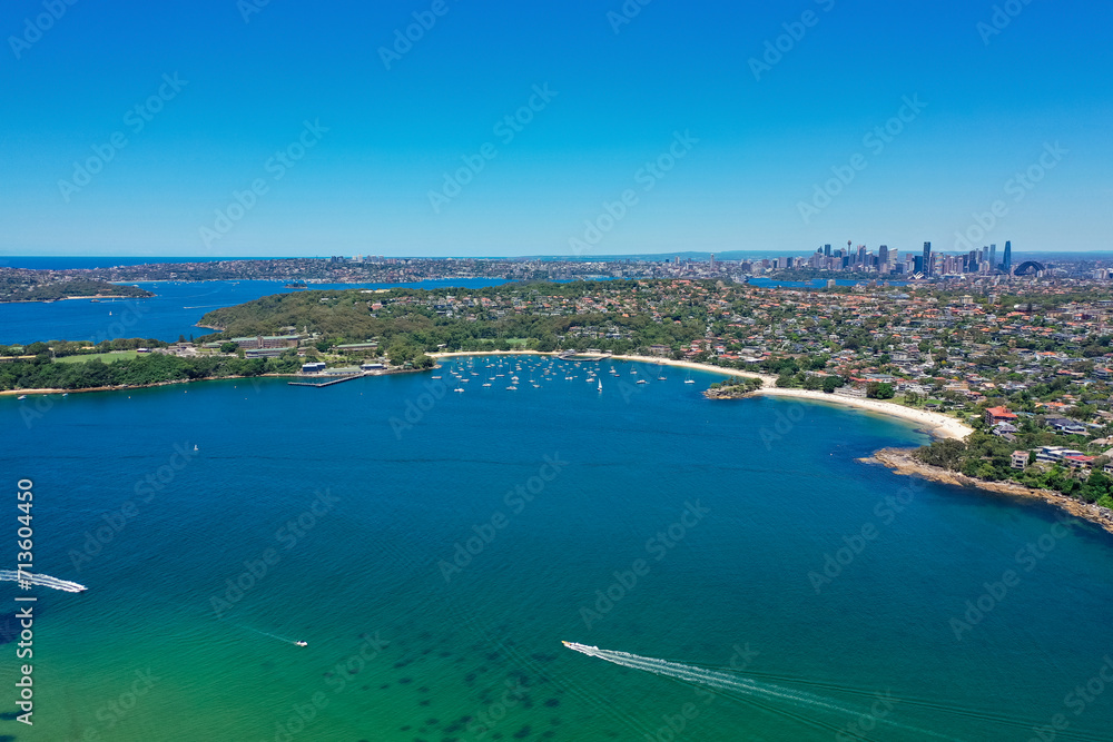 High angle aerial drone view of Balmoral Beach and Edwards Beach in the suburb of Mosman, Sydney, New South Wales, Australia. CBD and South Sydney in the background.