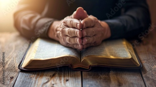 Man hands praying to god on the open bible on a wooden table. begging for forgiveness and believing in goodness. Pray for god blessing to wish to have a better life and life to be out of the crisis ph photo