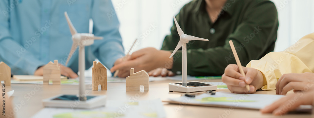 Green business meeting represented renewable energy. Skilled businesspeople discuss green business investment at table with environmental documents. Closeup. Focus on hand. Delineation. - obrazy, fototapety, plakaty 