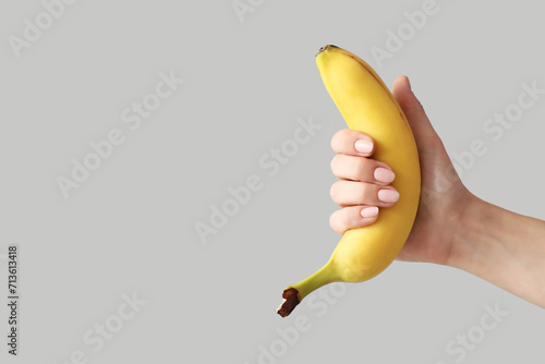 Woman with banana on light background. Sex concept