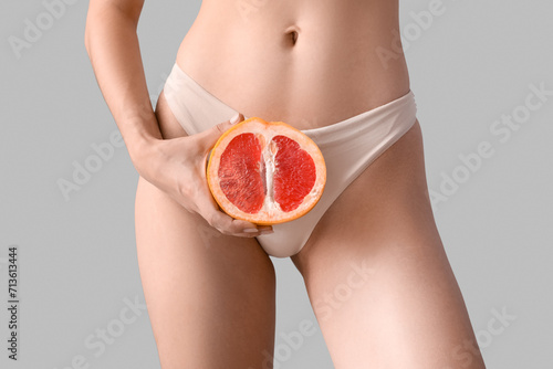 Woman with half of grapefru...