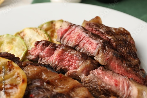 Delicious grilled beef steak and zucchini on plate, closeup