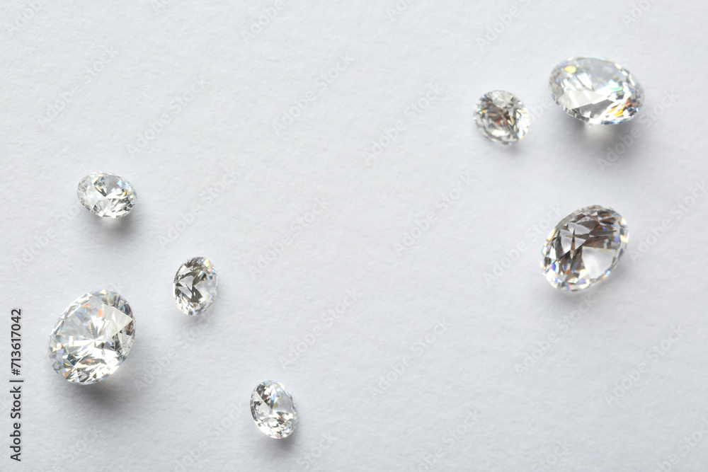 Many beautiful shiny diamonds on white background, flat lay. Space for text Many beautiful shiny diamonds on white background, flat lay. Space for text