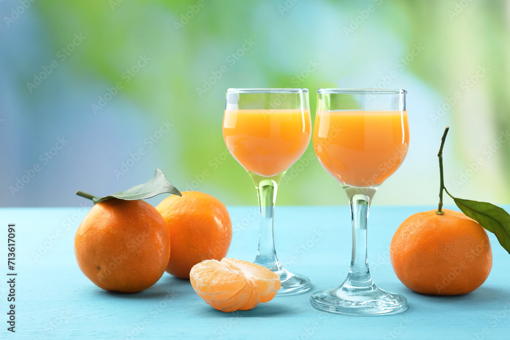 Delicious tangerine liqueur and fresh fruits on light blue wooden table