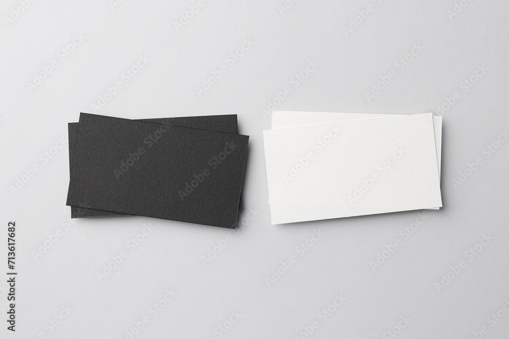 Blank black and white business cards on light background, flat lay. Mockup for design Blank black and white business cards on light background, flat lay. Mockup for design